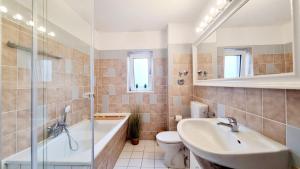 a bathroom with a sink and a tub and a toilet at 135m²-Apartment I max. 8 Gäste I Zentral I Küche I Balkon I Parken I WLAN in Lünen