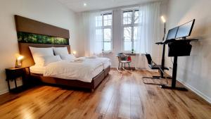 a bedroom with a bed and a desk with a television at 135m²-Apartment I max. 8 Gäste I Zentral I Küche I Balkon I Parken I WLAN in Lünen