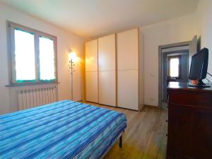 een slaapkamer met een bed, een tv en een dressoir bij appartamento in bifamiliare in Rosignano Solvay