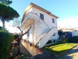 une maison blanche avec un escalier blanc dans une cour dans l'établissement appartamento in bifamiliare, à Rosignano Solvay