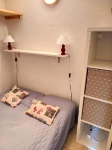 - une chambre avec un lit doté de deux oreillers et d'étagères dans l'établissement Résidence Arche - Studio pour 4 Personnes 084, à Magland