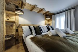 a bedroom with a large bed with white pillows at Résidence Cahokia - Chalets pour 13 Personnes 464 in Val-d'Isère