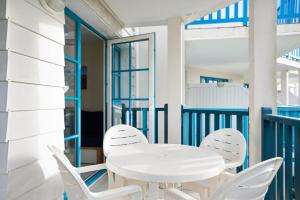 een witte tafel en stoelen op een balkon bij Résidence Port Bourgenay - maeva Home - 2 Pièces 7 Personnes Sélection 05 in Talmont