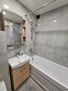 y baño con bañera blanca, lavamanos y bañera. en Pleasant stay 1-bedroom apartment, en Šiauliai