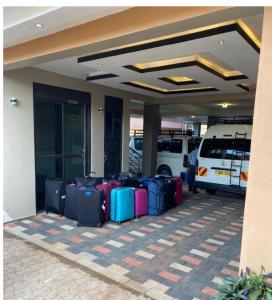 un montón de equipaje sentado fuera de un edificio en Javelin Hotel , Kampala, Uganda en Kampala