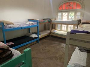 a room with three bunk beds and a window at Coolraul Hostel in Rosario