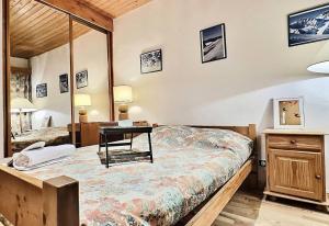 a bedroom with a bed and a desk at Résidence Hameaux De Val - 3 Pièces pour 6 Personnes 974 in Val-d'Isère
