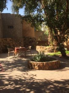 Bawati的住宿－New Oasis，公园内带桌椅的庭院