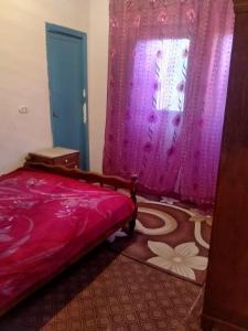 een slaapkamer met een rood bed en een raam bij New Oasis in Bawati