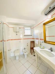 a bathroom with a toilet and a sink and a mirror at Casa Pippo 2 in Anacapri