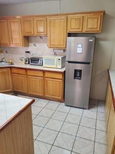 a kitchen with wooden cabinets and a stainless steel refrigerator at Elue's Inn in Mahaut