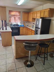 a kitchen with a counter and two bar stools at Elue's Inn in Mahaut