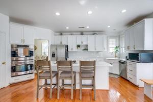 a kitchen with white cabinets and a table and chairs at Spacious Woodbridge Home Near Leesylvania Park! in Woodbridge