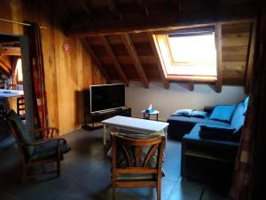 a living room with a couch and a tv at Résidence La Grange Des Flocons - Chalets pour 12 Personnes 894 in Valloire