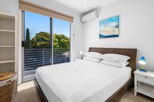 a bedroom with a white bed and a large window at Nice & Quiet 2-Bed by Shops & Airport in Melbourne