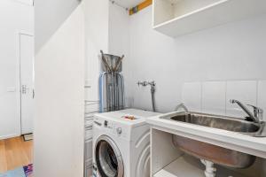 a kitchen with a washing machine and a sink at Nice & Quiet 2-Bed by Shops & Airport in Melbourne