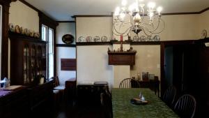 a dining room with a green table and a chandelier at Mountain Home Bed & Breakfast in Front Royal