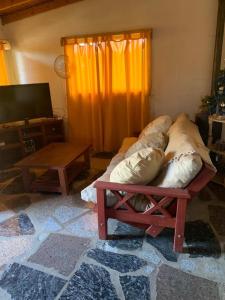 1 dormitorio con cama, mesa y TV en Aquellos Diaz- Cabaña con vista a las Sierras - Pileta - Wifi - Cochera techada - Aceptamos mascotas en Huerta Grande