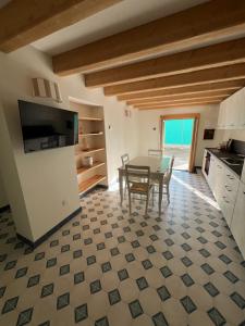 cocina con mesa y sillas en una habitación en Appartamento Fronte Laguna Ca’Nonica en SantʼAntonio