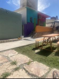 a picnic table sitting on grass in front of a building at Lo de Nenè hostal in Cosquín