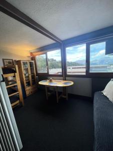 a room with a bed and a table and windows at Résidence Vercors - Studio pour 4 Personnes 374 in Aime-La Plagne