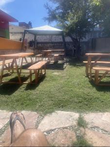 grupa drewnianych stołów piknikowych w parku w obiekcie Lo de Nenè hostal w mieście Cosquín