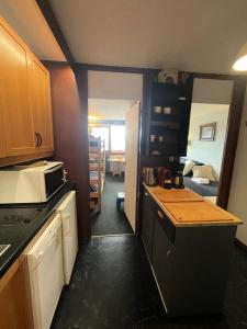a kitchen with a counter and a room with a bed at Résidence Vercors - Studio pour 4 Personnes 374 in Aime-La Plagne