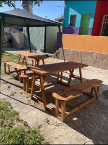 grupa stołów piknikowych siedzących pod parasolem w obiekcie Lo de Nenè hostal w mieście Cosquín