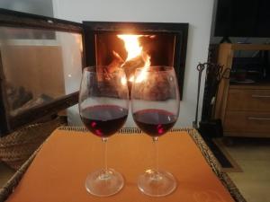 due bicchieri di vino rosso davanti al camino di XimoApartments AP-3 Primera LÍNEA Playa y CHIMENEA a Oliva