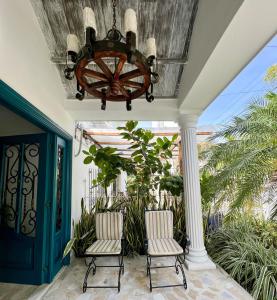 a porch with two chairs and a chandelier at Peregrinos Hostel Cartagena de Indias in Cartagena de Indias