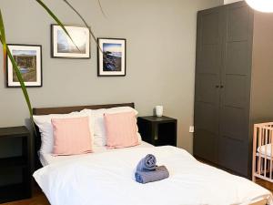 ein Schlafzimmer mit einem weißen Bett mit rosa Kissen in der Unterkunft Rodinný byt pro 4 na Brno-střed in Brünn