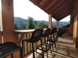 a row of chairs sitting on a deck with a table at Résidence LUMI BATIMENT B - Appartement LUMI B pour 4 Personnes 014 in Valmorel
