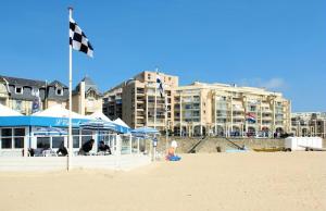 a flag on a beach with buildings in the background at Résidence Les Océanes - maeva Home - Studio 5 Personnes Confort - vue mer MAE-5816 in Pornichet +11 photos