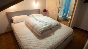 een bed met witte lakens en kussens erop bij Chalet De Florence - 3 Pièces pour 8 Personnes 124 in Modane