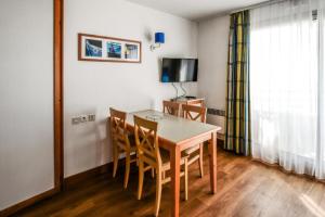 a dining room with a table and chairs and a television at Résidence Les Océanes - maeva Home - Studio 5 Personnes Confort - vue mer MAE-5816 in Pornichet