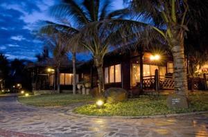 ein Haus mit Palmen und Lichtern davor in der Unterkunft Ocean Star Resort in Mui Ne