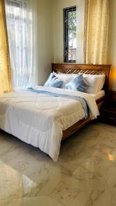 a large bed in a bedroom with a window at Safi House in Boma la Ngombe