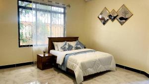 um quarto com uma cama grande e uma janela em Safi House em Boma la Ngombe