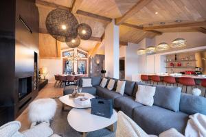 a living room with a blue couch and tables at Résidence Rosoire - Chalets pour 12 Personnes 994 in Courchevel