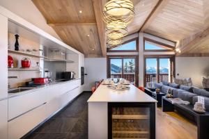 a kitchen and living room with a couch and a table at Résidence Rosoire - Chalets pour 12 Personnes 994 in Courchevel