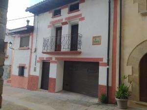 un edificio blanco y rojo con garaje en Casa Rural La Maestra, 
