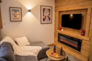 a living room with a couch and a fireplace at Résidence Domaine Du Loup Blanc - Chalets pour 8 Personnes 514 in Les Orres