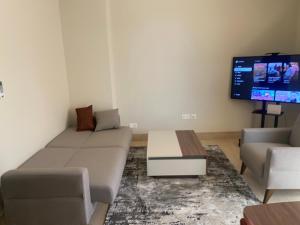 a living room with a couch and a flat screen tv at إطلالة هوانا in Ma‘mūrah