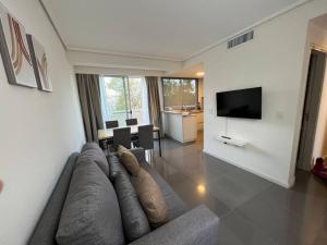 a living room with a large couch and a television at Departamento excelente ubicación Capital Mendoza in La Cieneguita