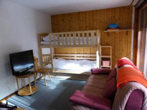 een woonkamer met een bank en een stapelbed bij Résidence Les Trolles - 2 Pièces pour 4 Personnes 374 in Les Contamines-Montjoie