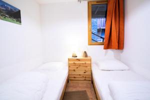 een slaapkamer met 2 bedden en een spiegel bij Les Chalets Petit Bonheur - Chalets pour 6 Personnes 484 in Villarodin-Bourget