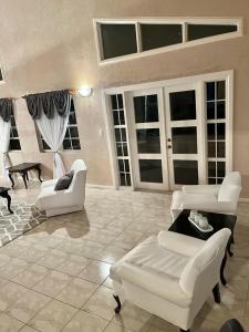 a large living room with white furniture and windows at Paradise View Hilltop 5 Bedroom Residence in Dickenson Bay