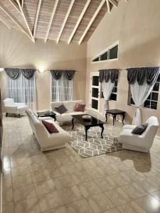 a large living room with white furniture and windows at Paradise View Hilltop 5 Bedroom Residence in Dickenson Bay