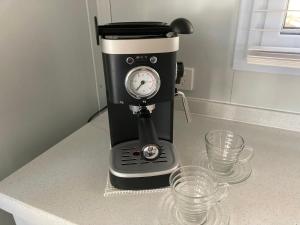 a coffee maker sitting on a counter with two glasses at Stephanie’s Country Cottages in Drummond