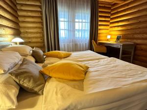 a bedroom with two beds with yellow pillows and a desk at Szent Orbán Erdei Wellness Hotel in Kóspallag